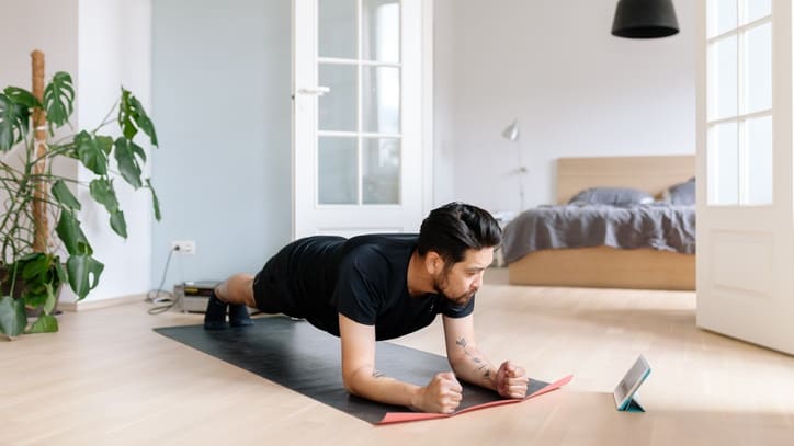 A man doing push ups in his living room.