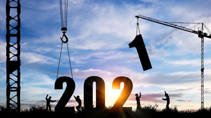 Silhouettes of construction workers and cranes with the year 2020 in the background.