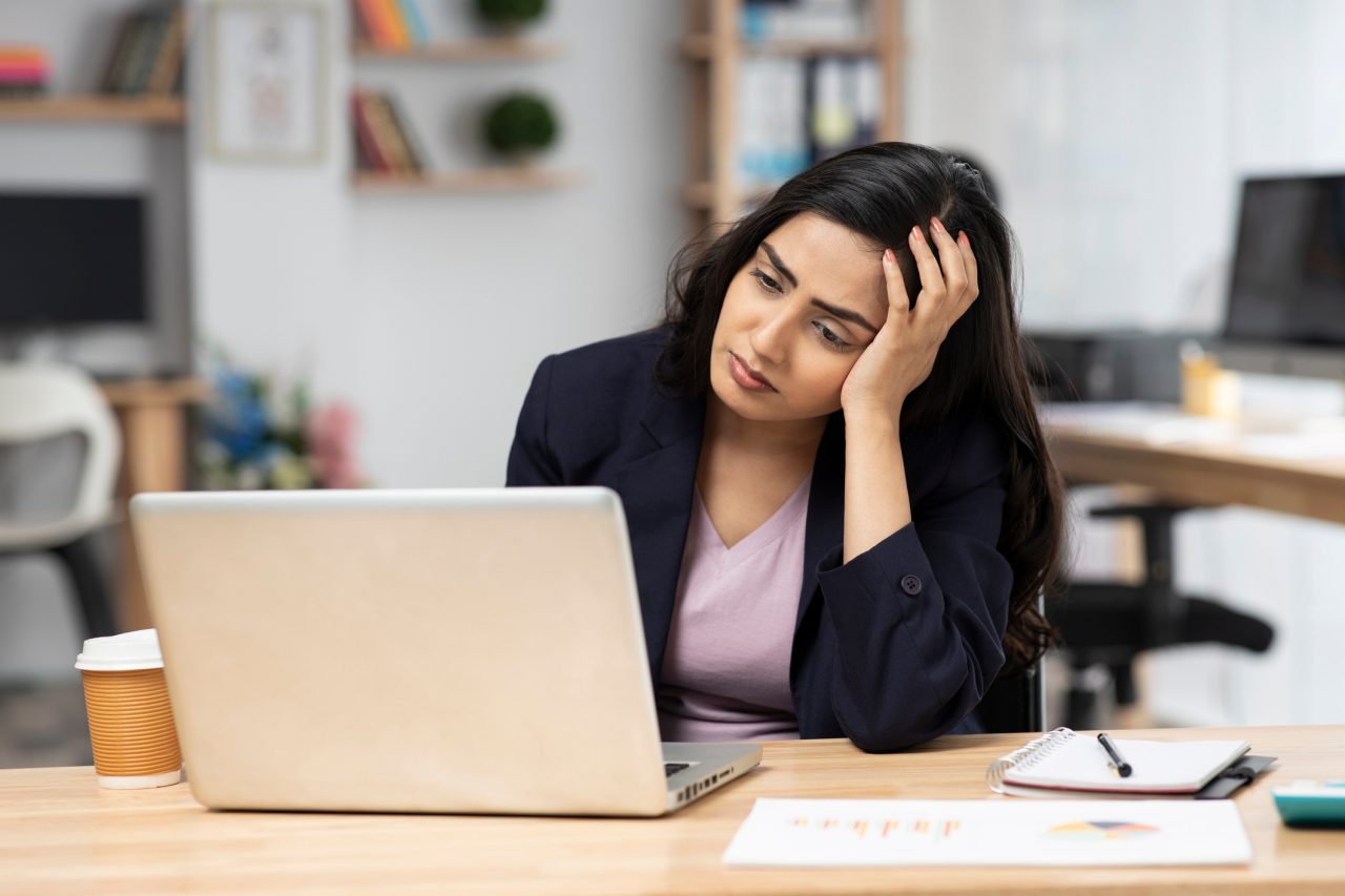 Young woman in office working on laptop