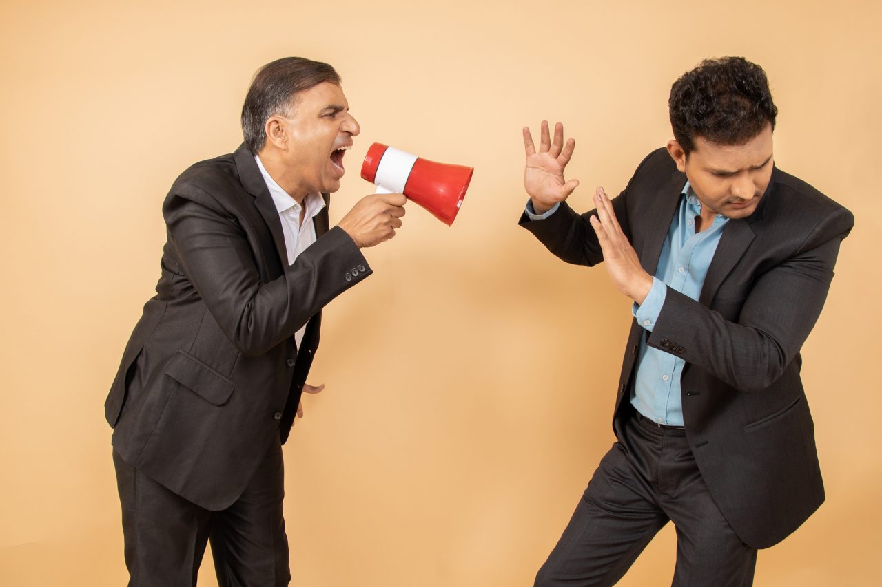angry boss shouting on his employee 