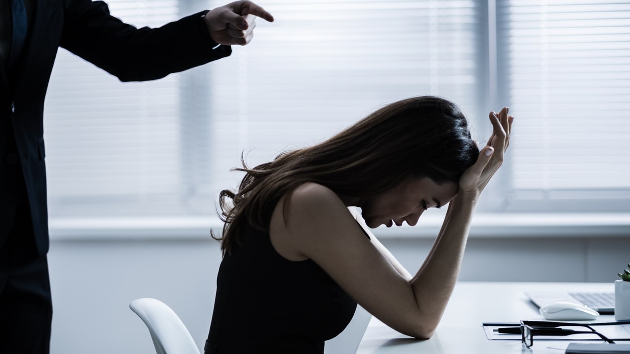 A man is pointing his finger at a woman in an office.