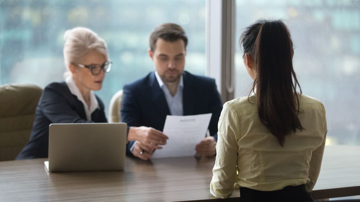 A group of people sitting around a table in a business meeting.