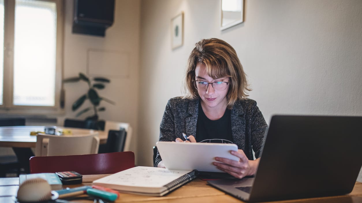 A woman working at a table with a laptop.