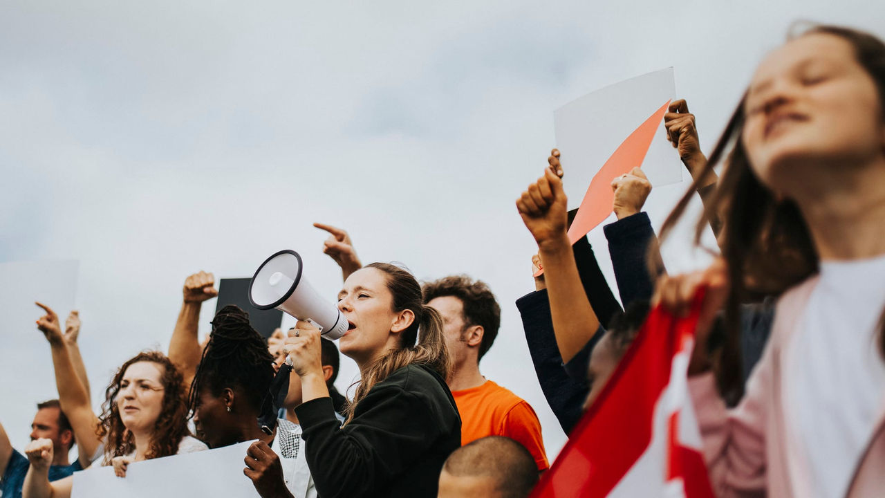 A group of people holding signs and a megaphone.