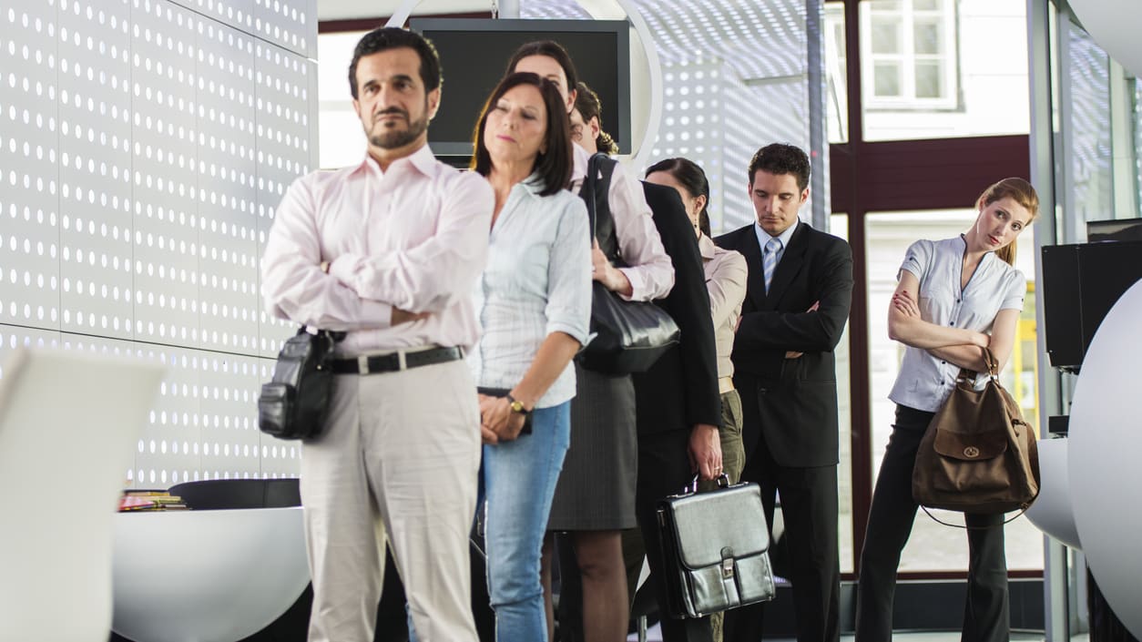 A group of business people standing in a lobby.