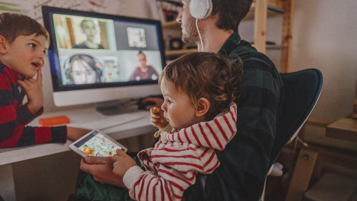 A man and two children are watching a video on a computer.