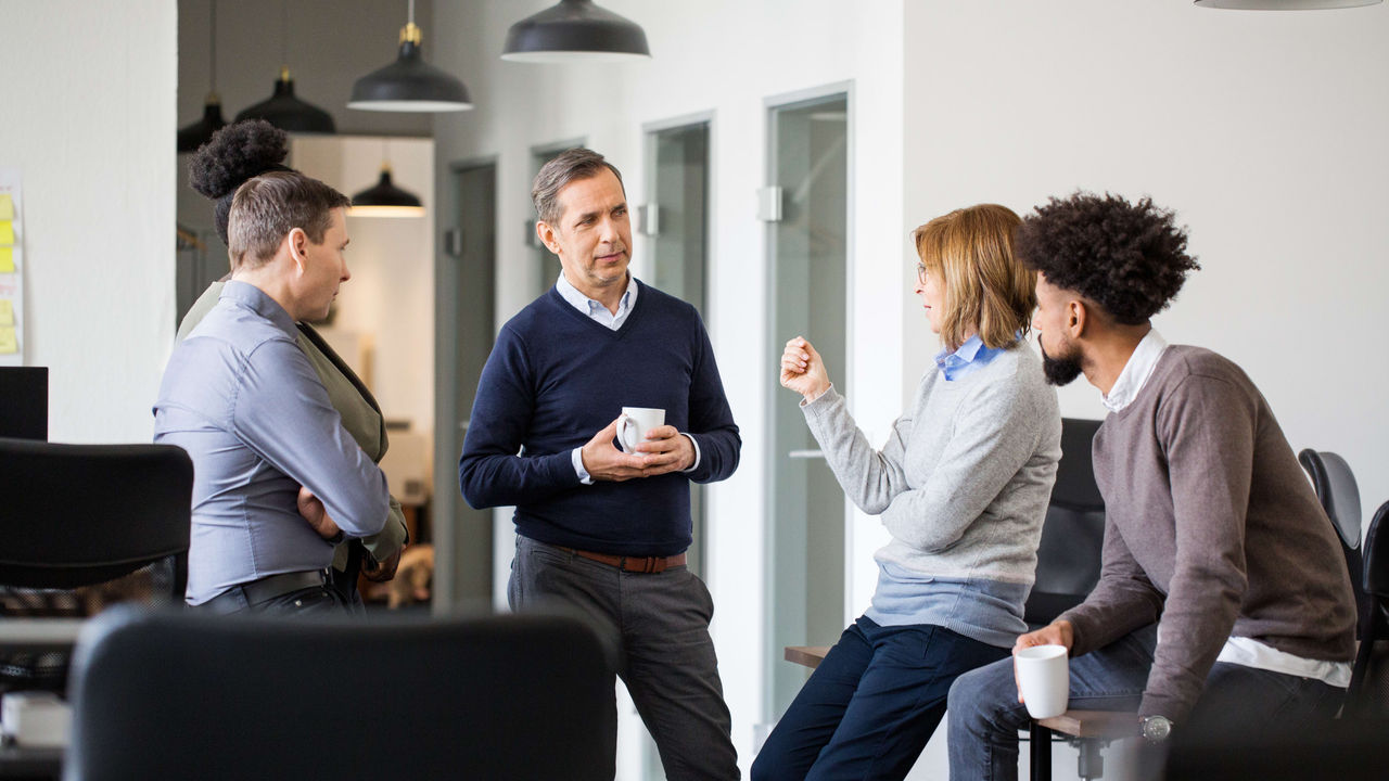 A group of people talking in an office.