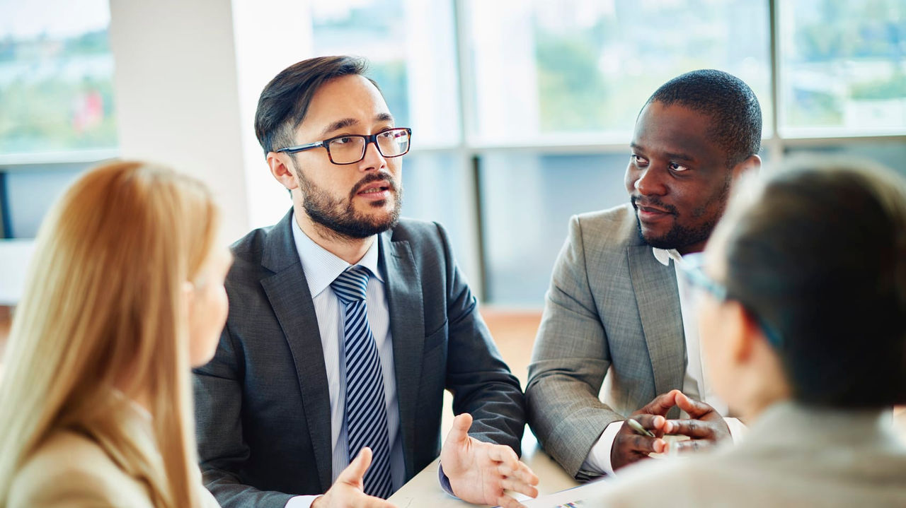 A group of business people talking at a meeting.