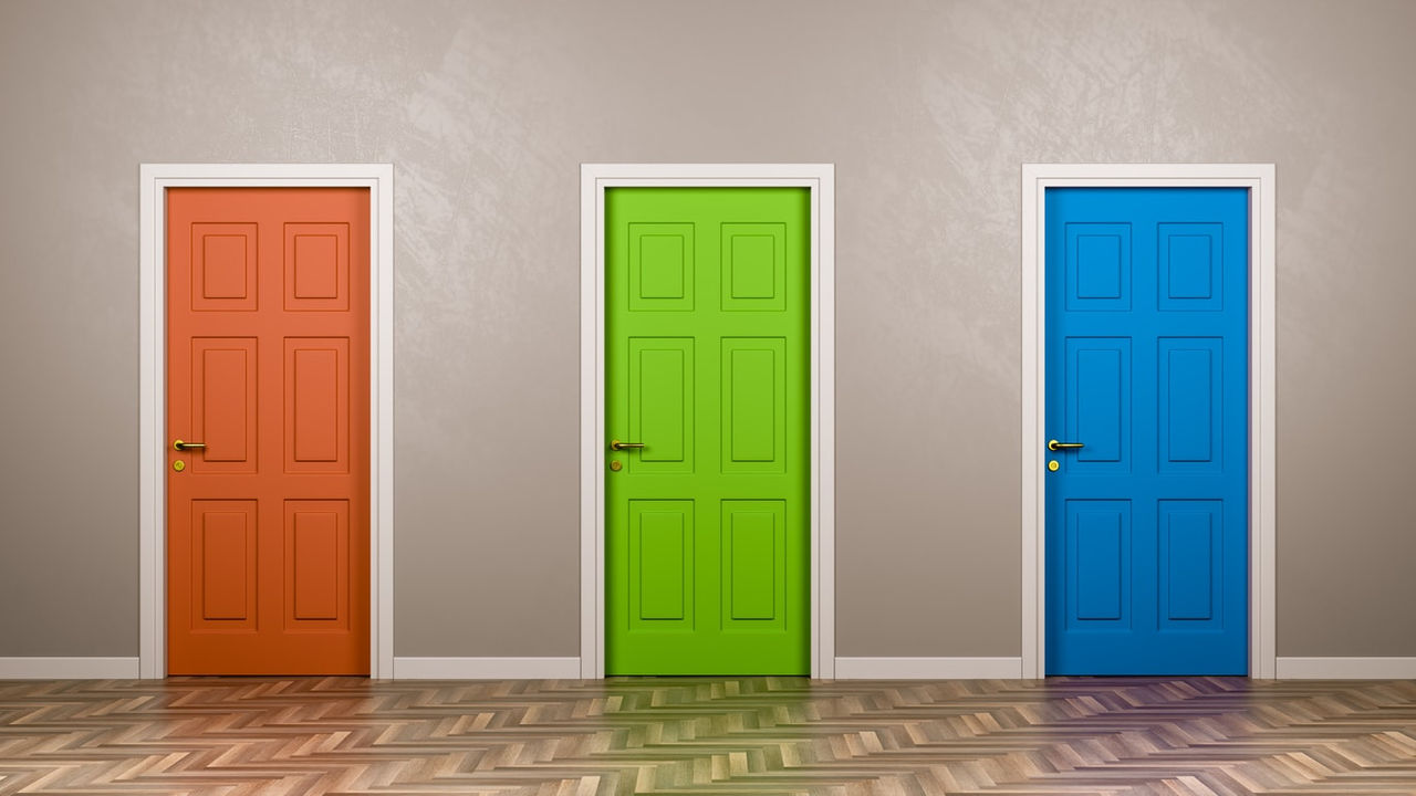 Three colorful doors in a row on a wooden floor.