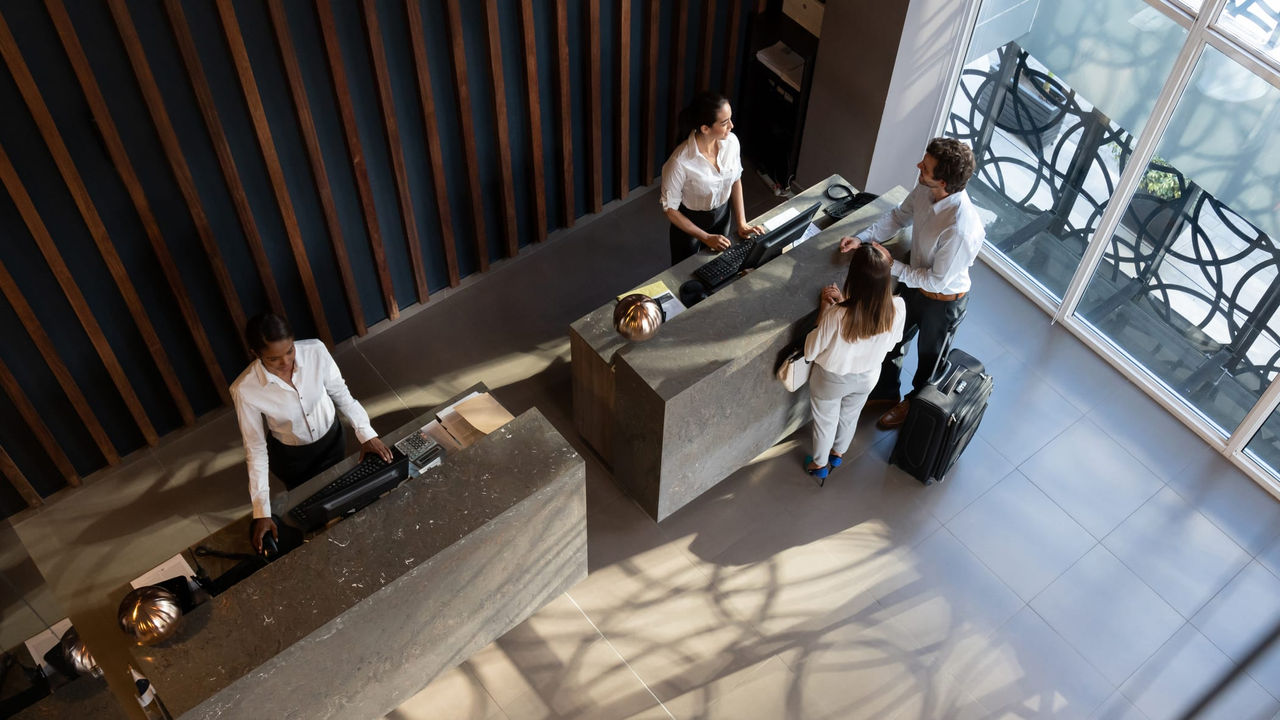 A group of people standing at a reception desk.