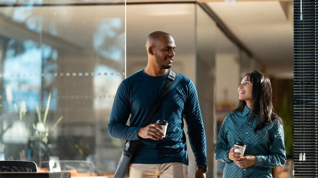 A man and woman walking through a glass door.