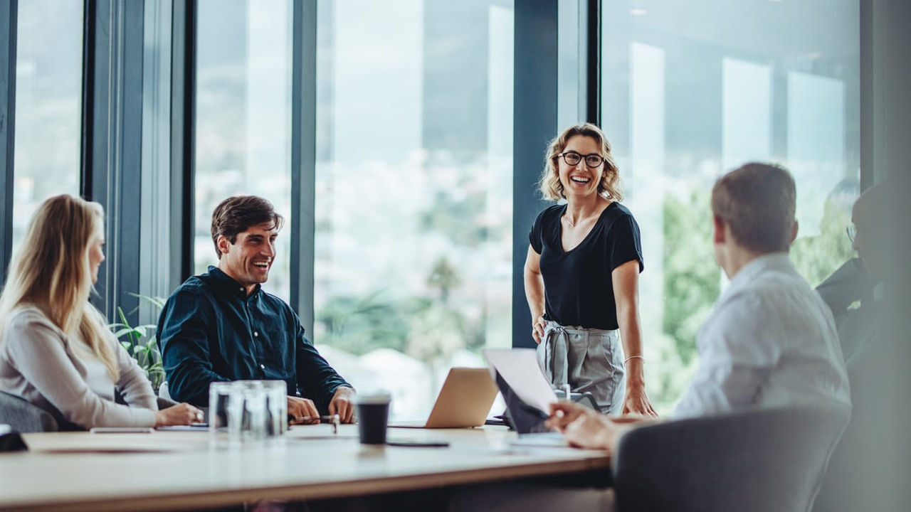 A group of people sitting around a table in a conference room.