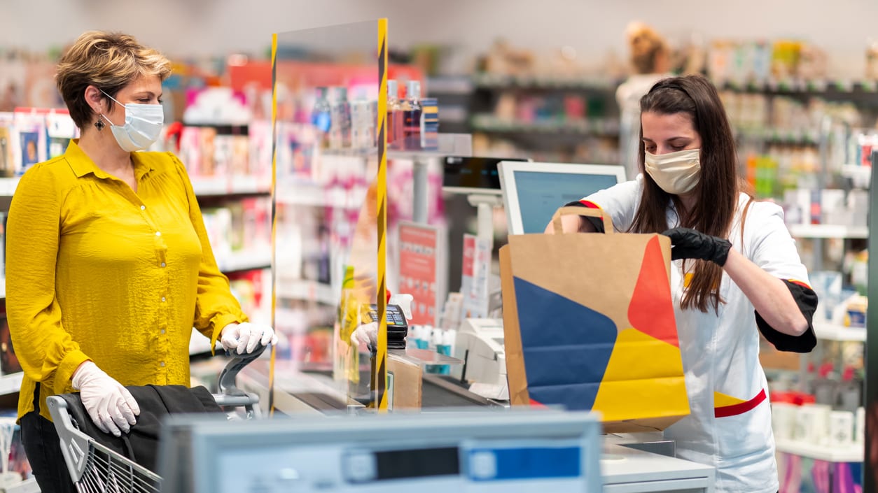 Two women wearing face masks in a pharmacy.