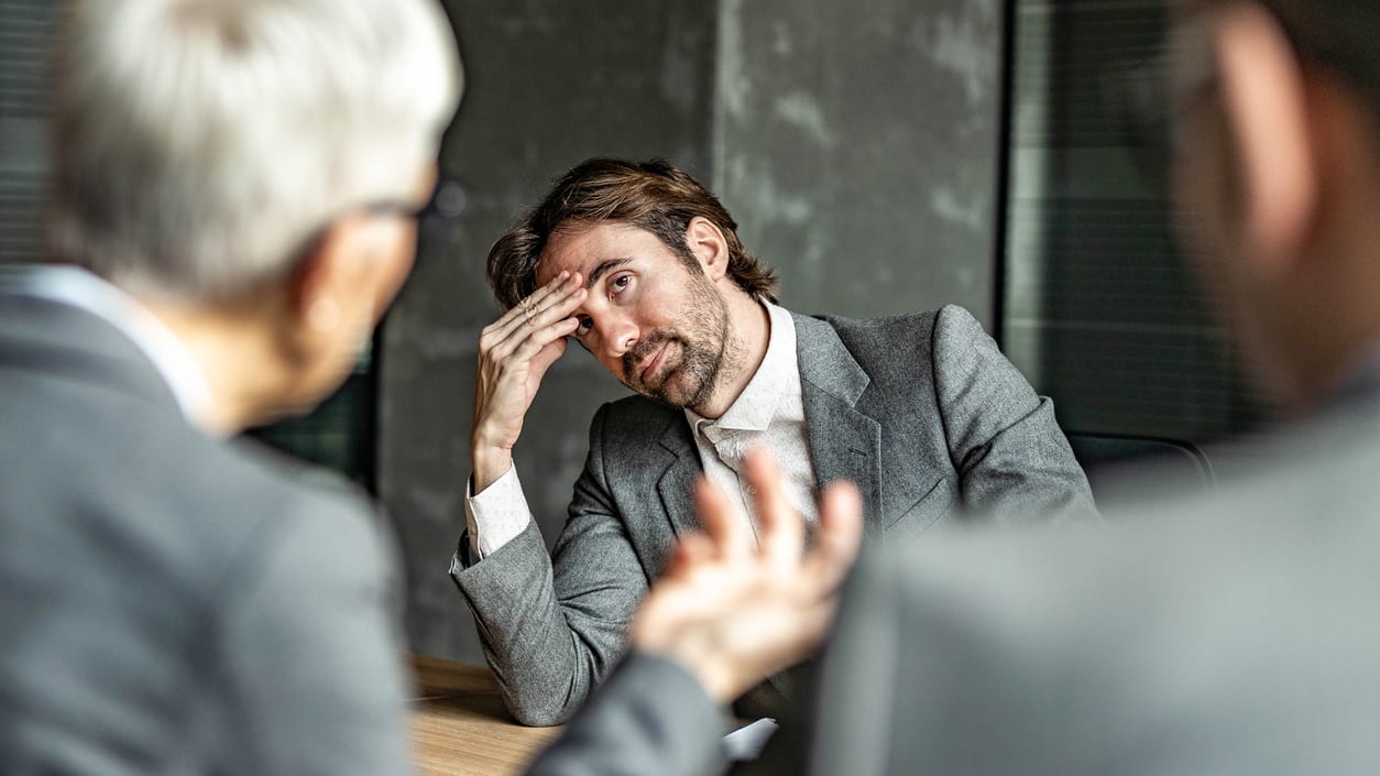 A group of businessmen sitting at a table in a meeting.