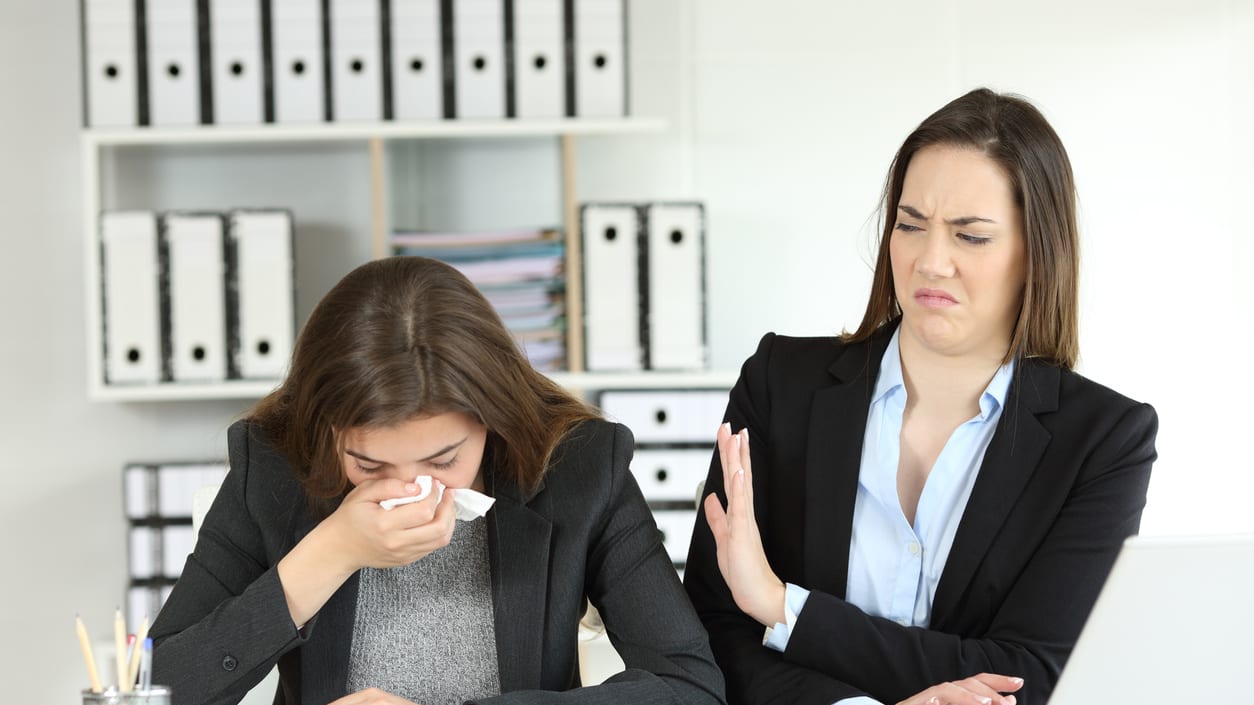 Two women sitting at a desk in an office.