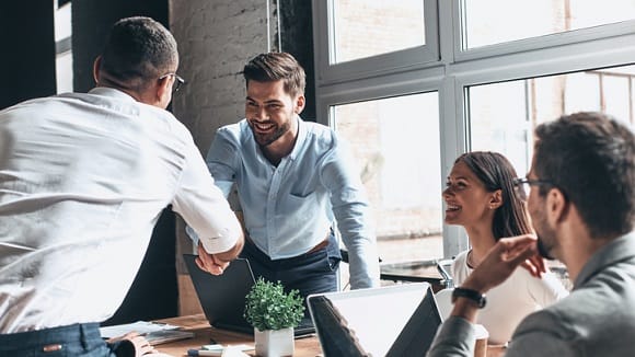 A group of business people shaking hands in an office.