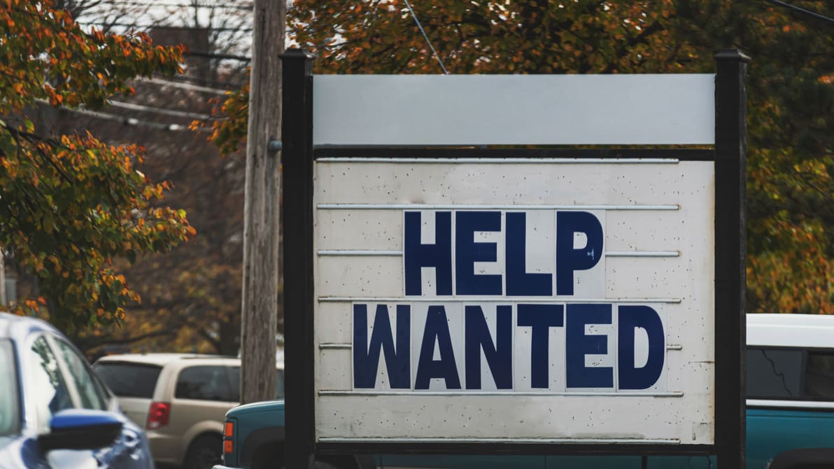 A sign that says help wanted.