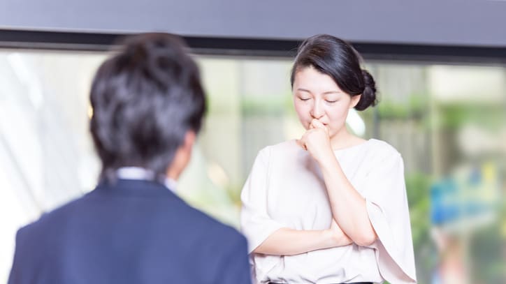 A woman is talking to a man in an office.