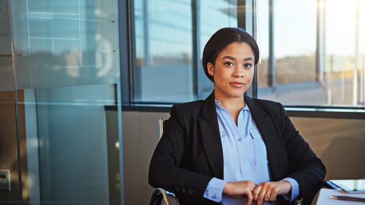 A business woman sitting at a desk in an office.