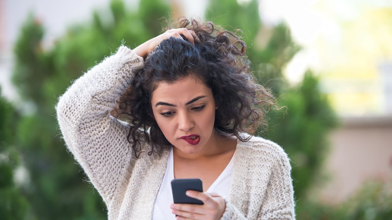 A woman looking at her phone in the street.