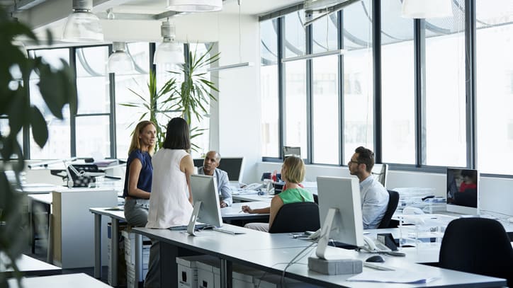 A group of people sitting at desks in an office.