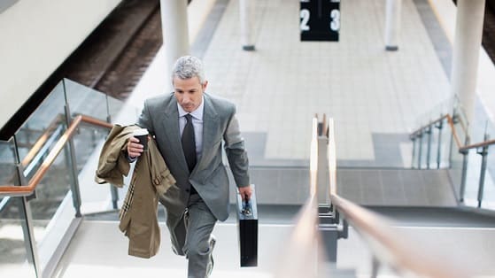 Businessman walking up stairs with briefcase.