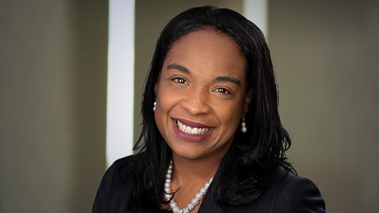 A woman in a business suit smiling for the camera.