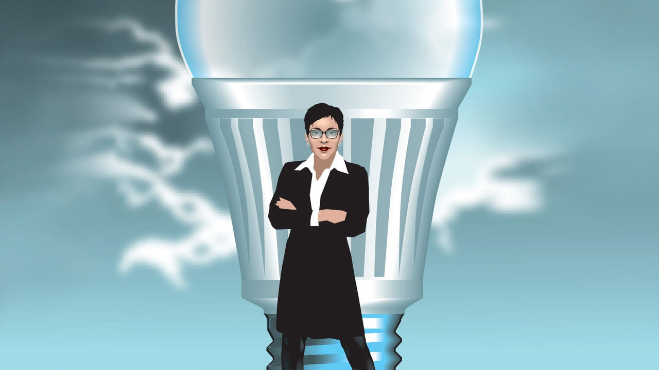 A business woman standing next to a light bulb.