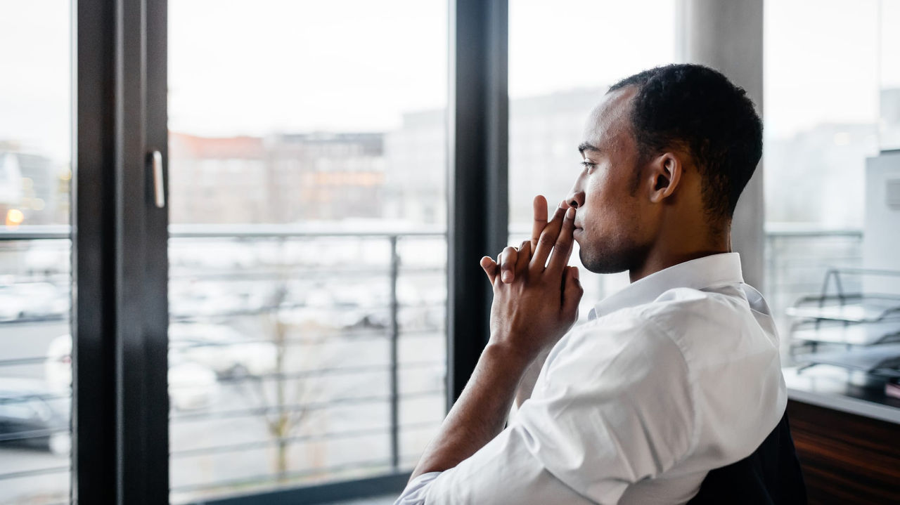 Young african american businessman sitting in front of a window.