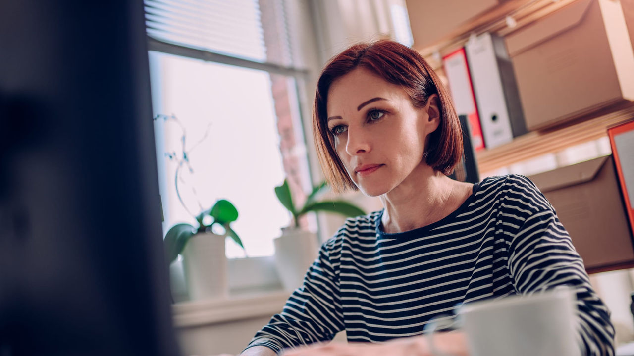 A woman working on a computer in her home office.