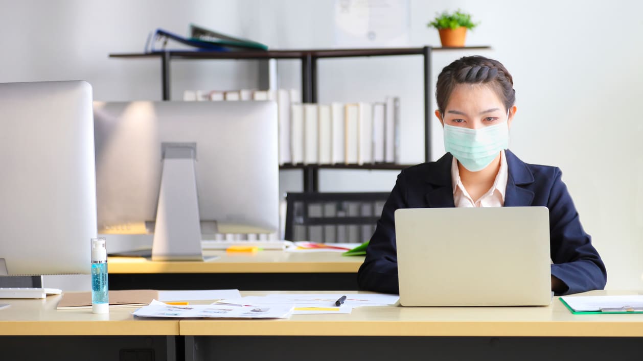 Asian business woman wearing a face mask in the office.