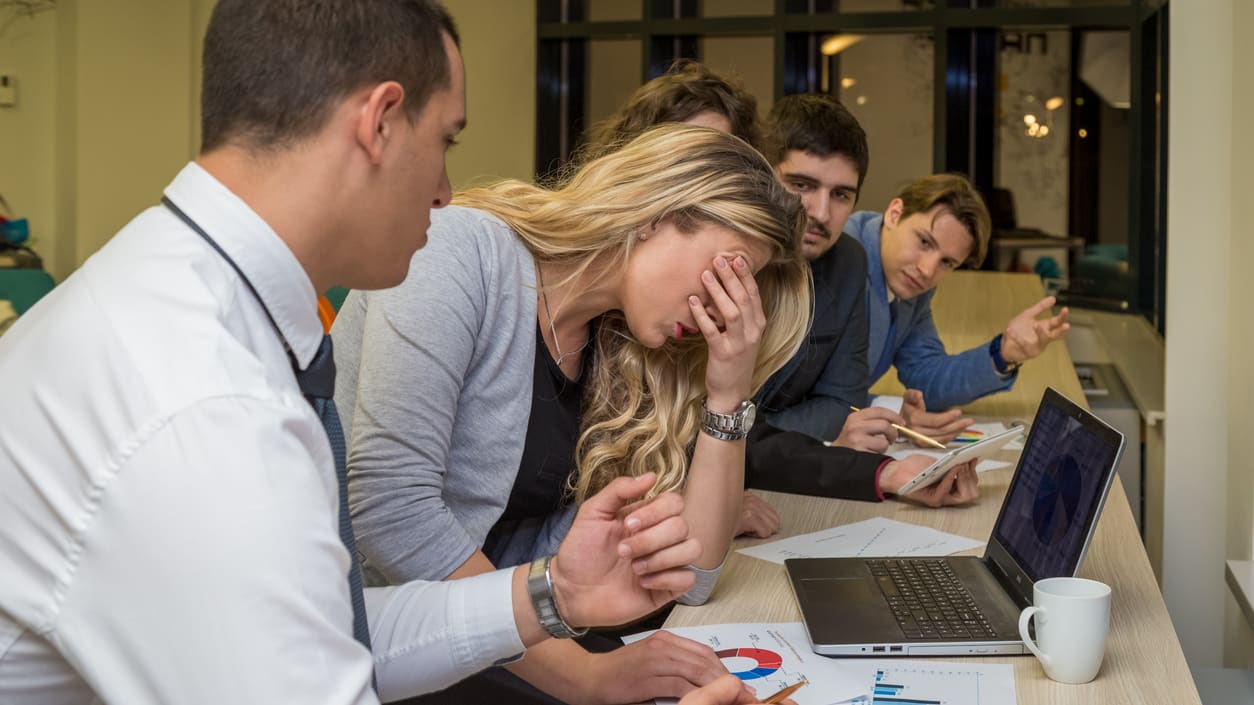 A group of people sitting around a table in an office.