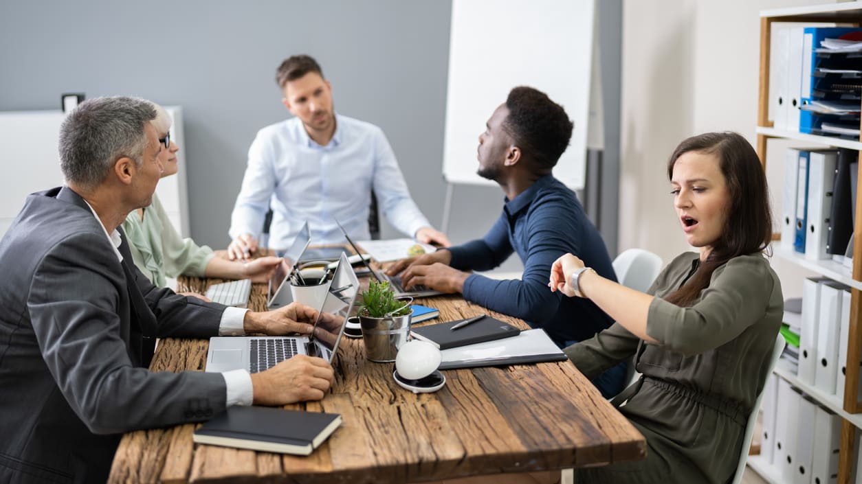 A group of people sitting around a table in an office.