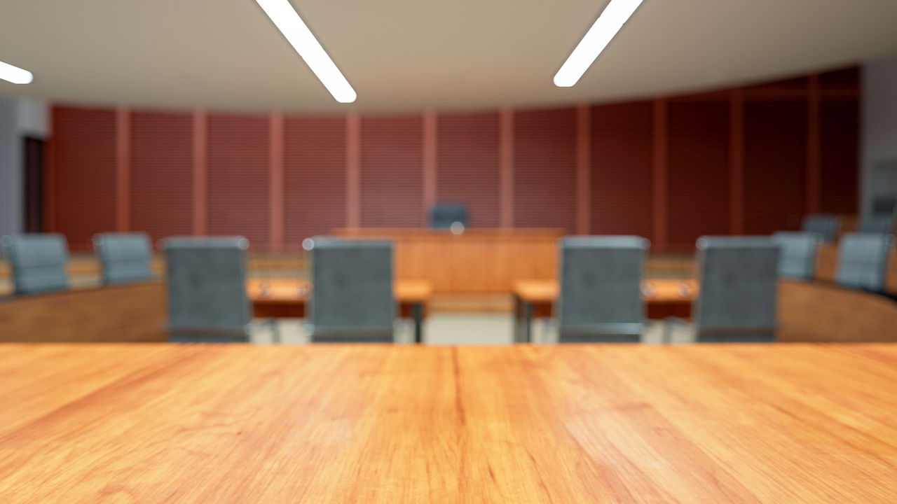An empty conference room with a wooden table and chairs.
