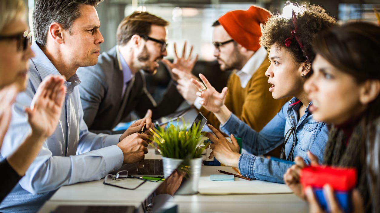 A group of people clapping at a conference table.