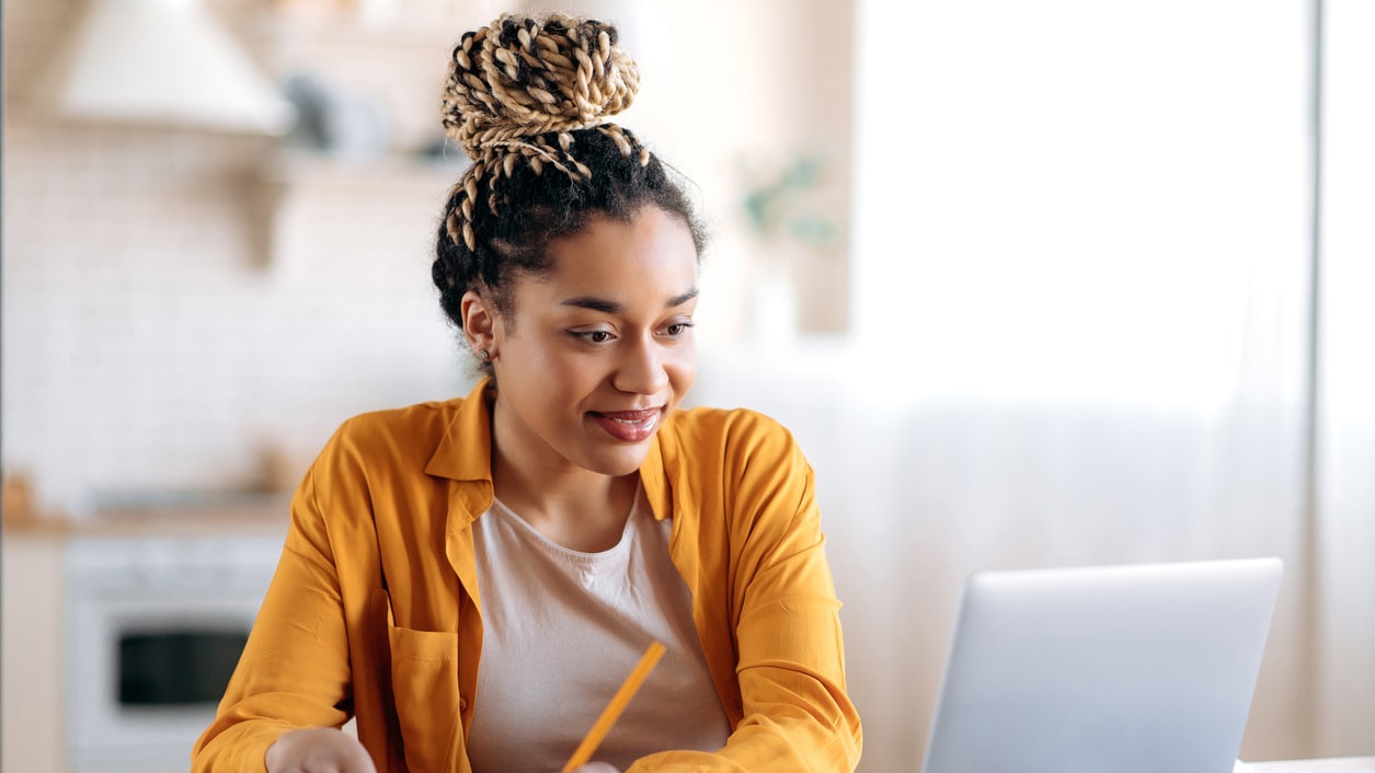 A young woman working on her laptop at home.