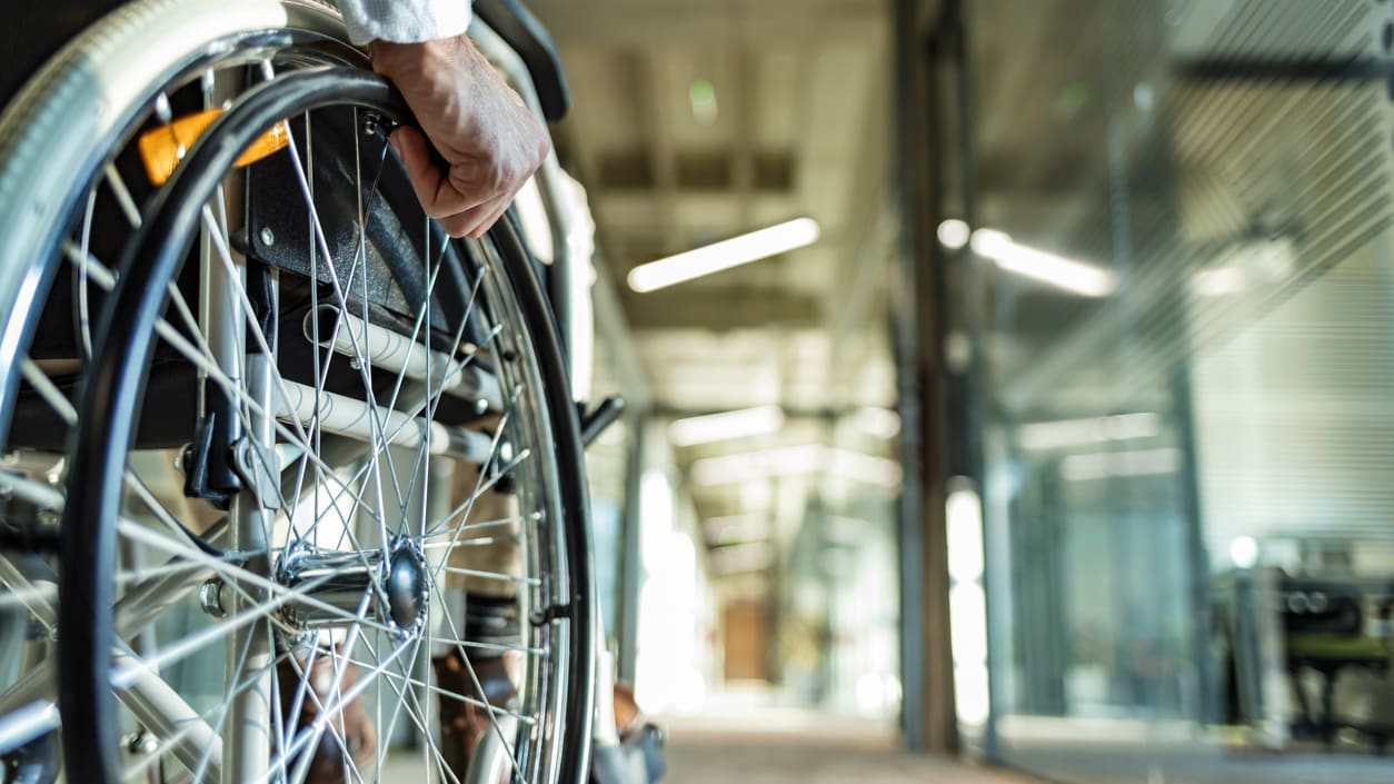 A person in a wheelchair is walking down a hallway.