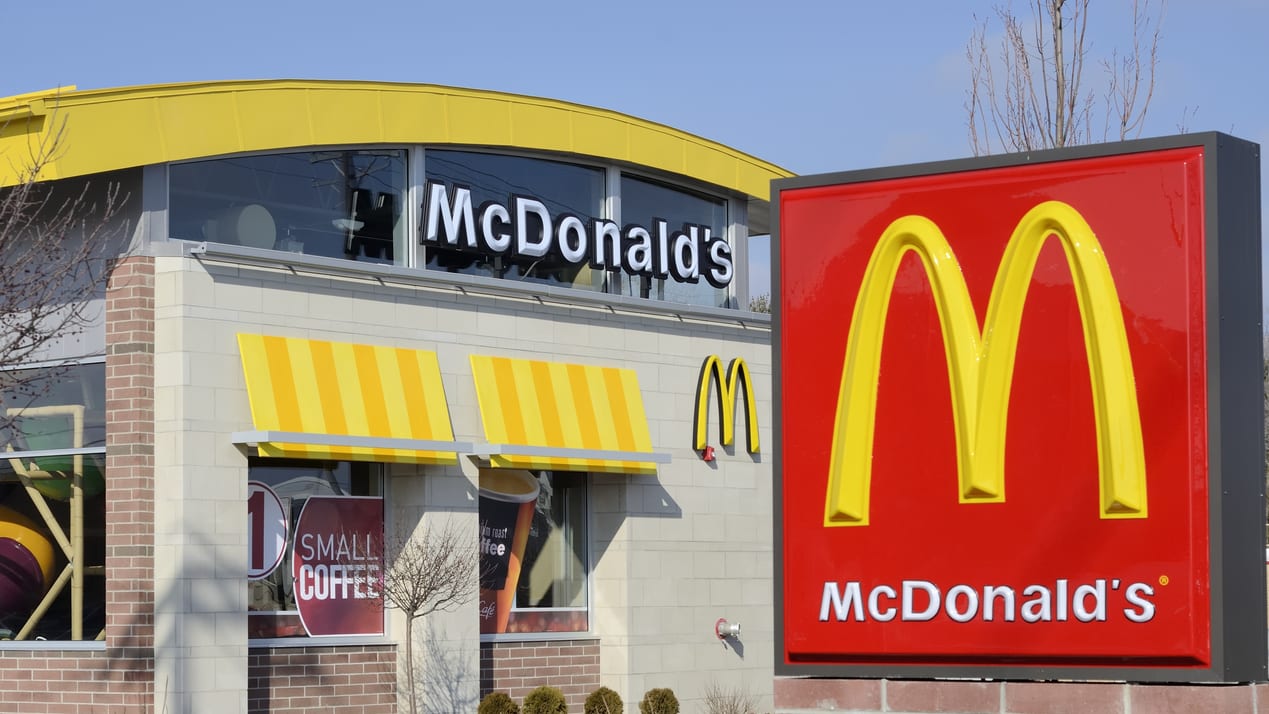 A mcdonald's restaurant with a sign in front of it.