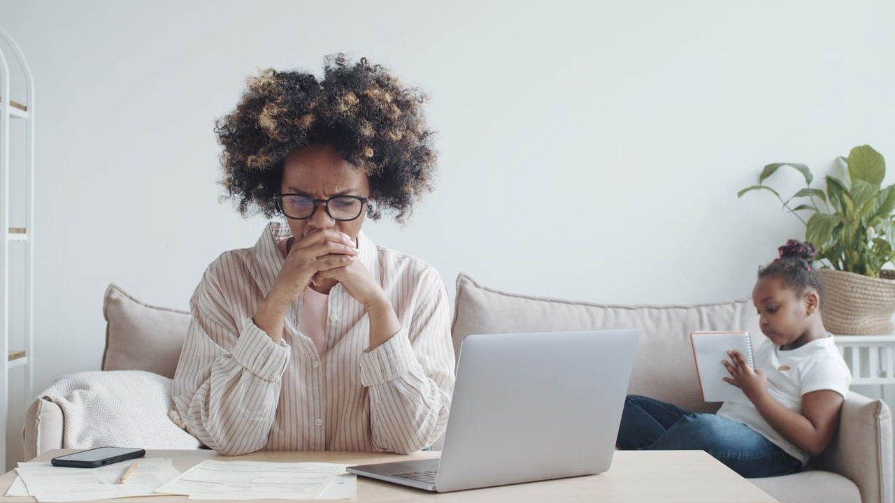 A woman sitting on a couch with a laptop in front of her.