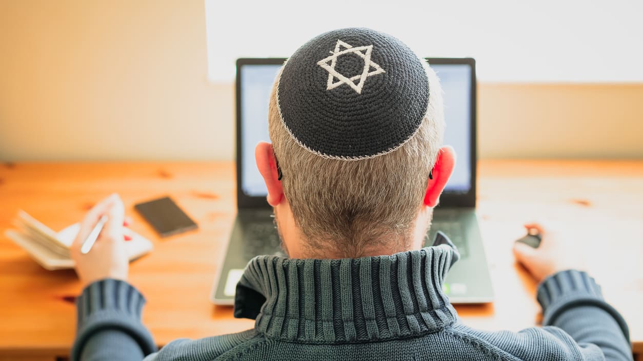 A man wearing a hat with a star of david on it.