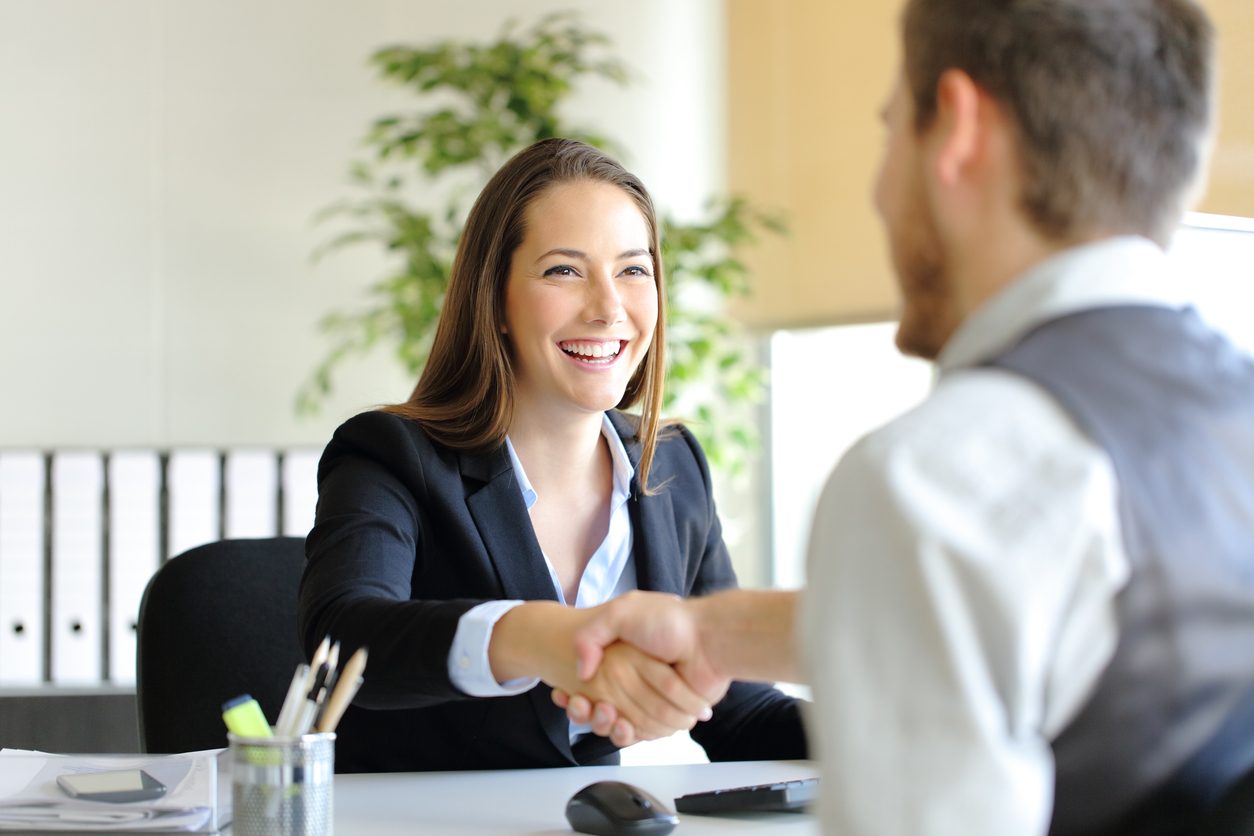 A young professional begins a job interview with an enthusiastic expression. 