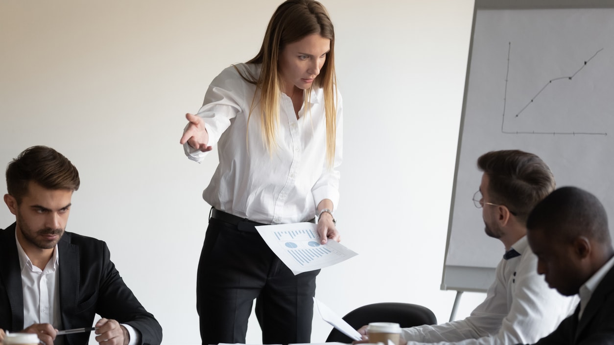 A woman is giving a presentation to a group of people at a meeting.