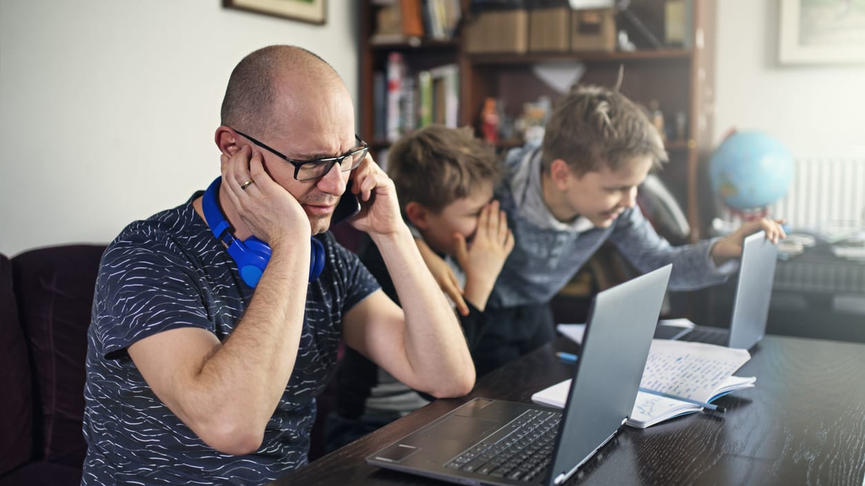 A man and his son are sitting at a table with a laptop.