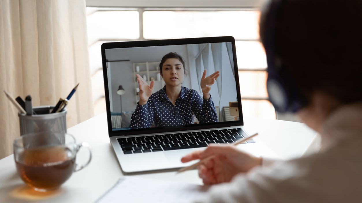 A woman is using a laptop to make a video call.