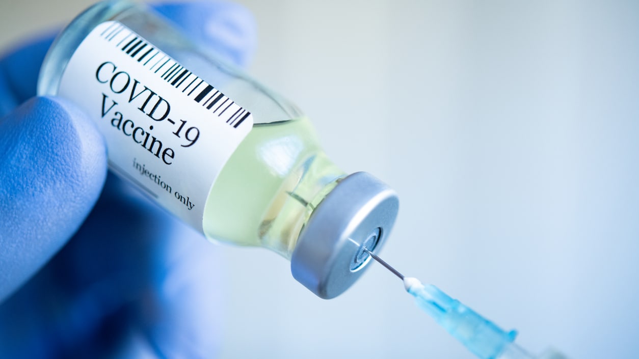 A syringe is being injected with a covid vaccine.