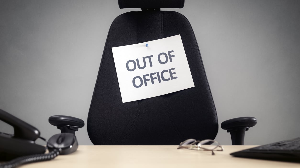 An office chair with a sign saying out of office.