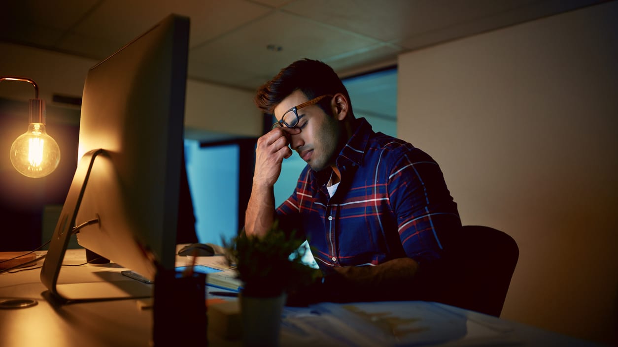 A man sitting in front of a computer at night.