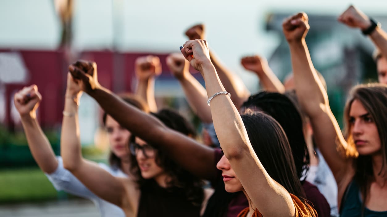 A group of people raising their fists in the air.