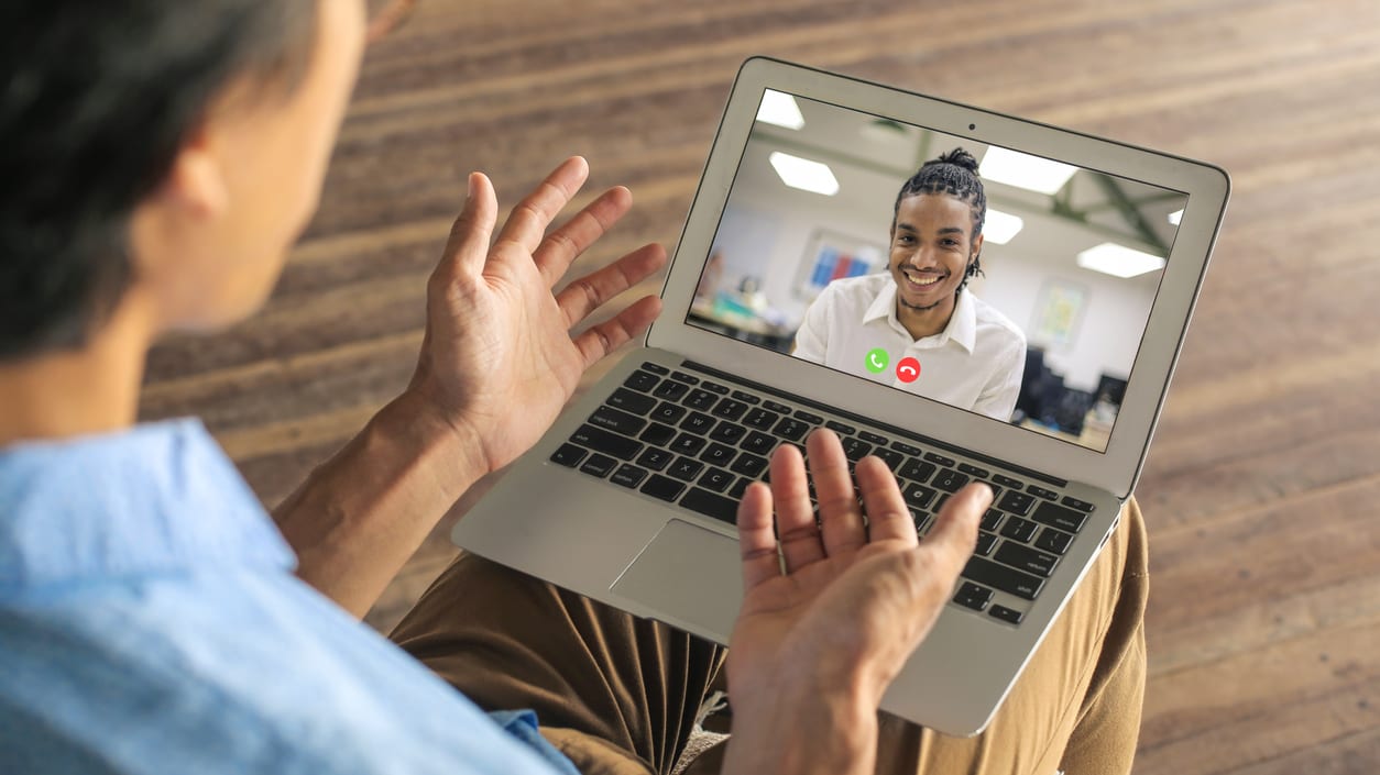 A man having a video call using a laptop.