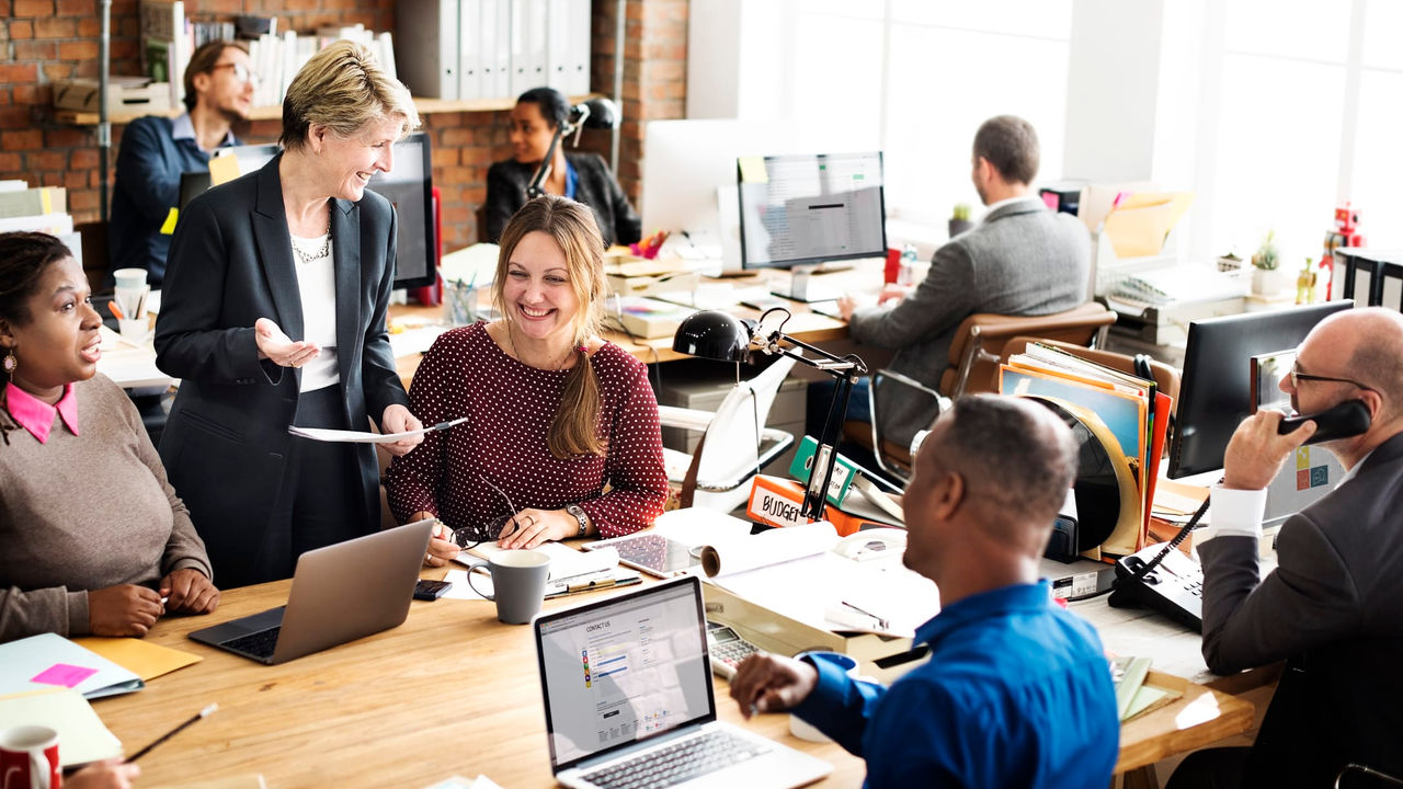 A group of people sitting around a table in an office.